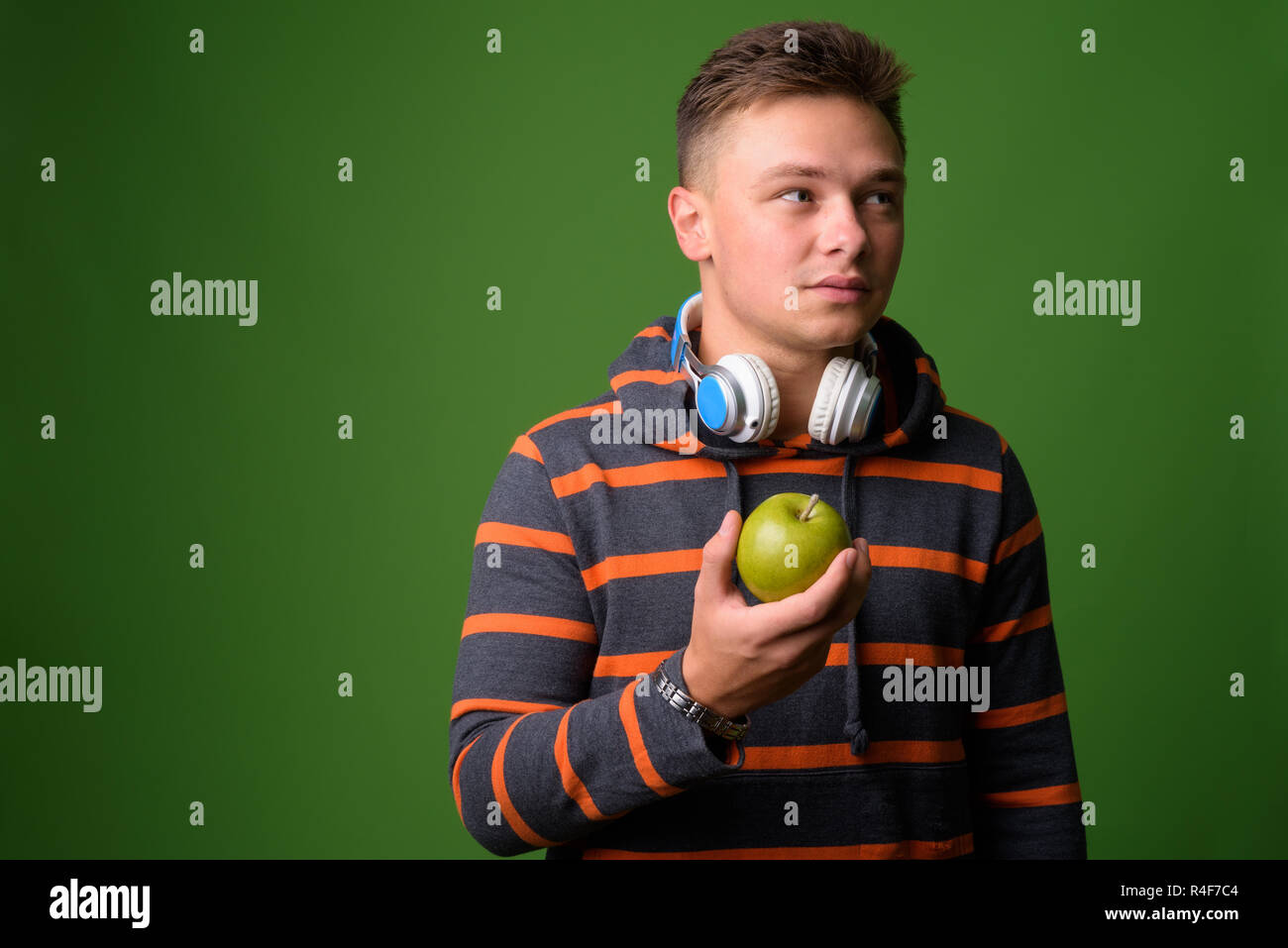 Studio shot of young handsome man against green background Stock Photo