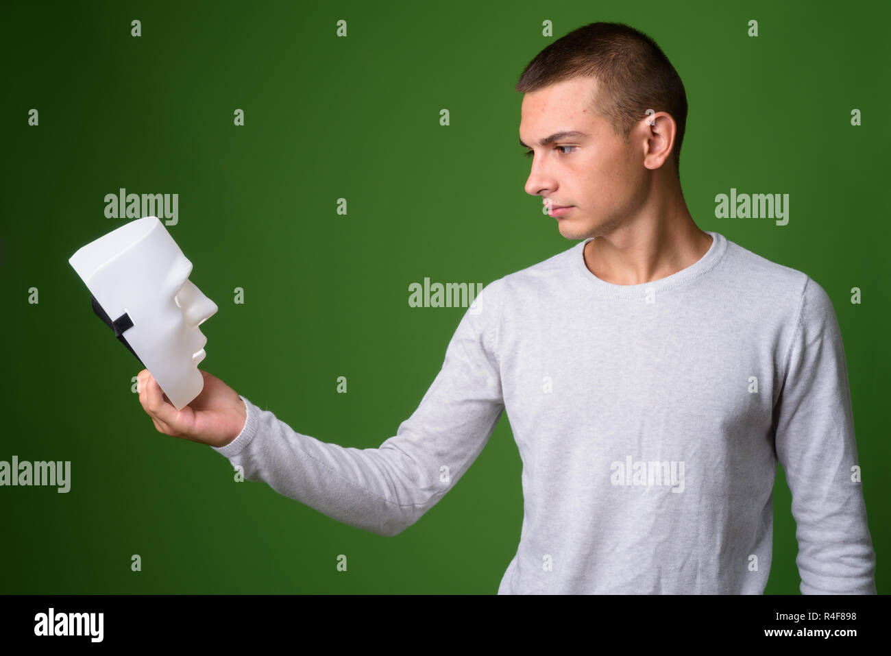 Studio shot of young handsome man against green background Stock Photo