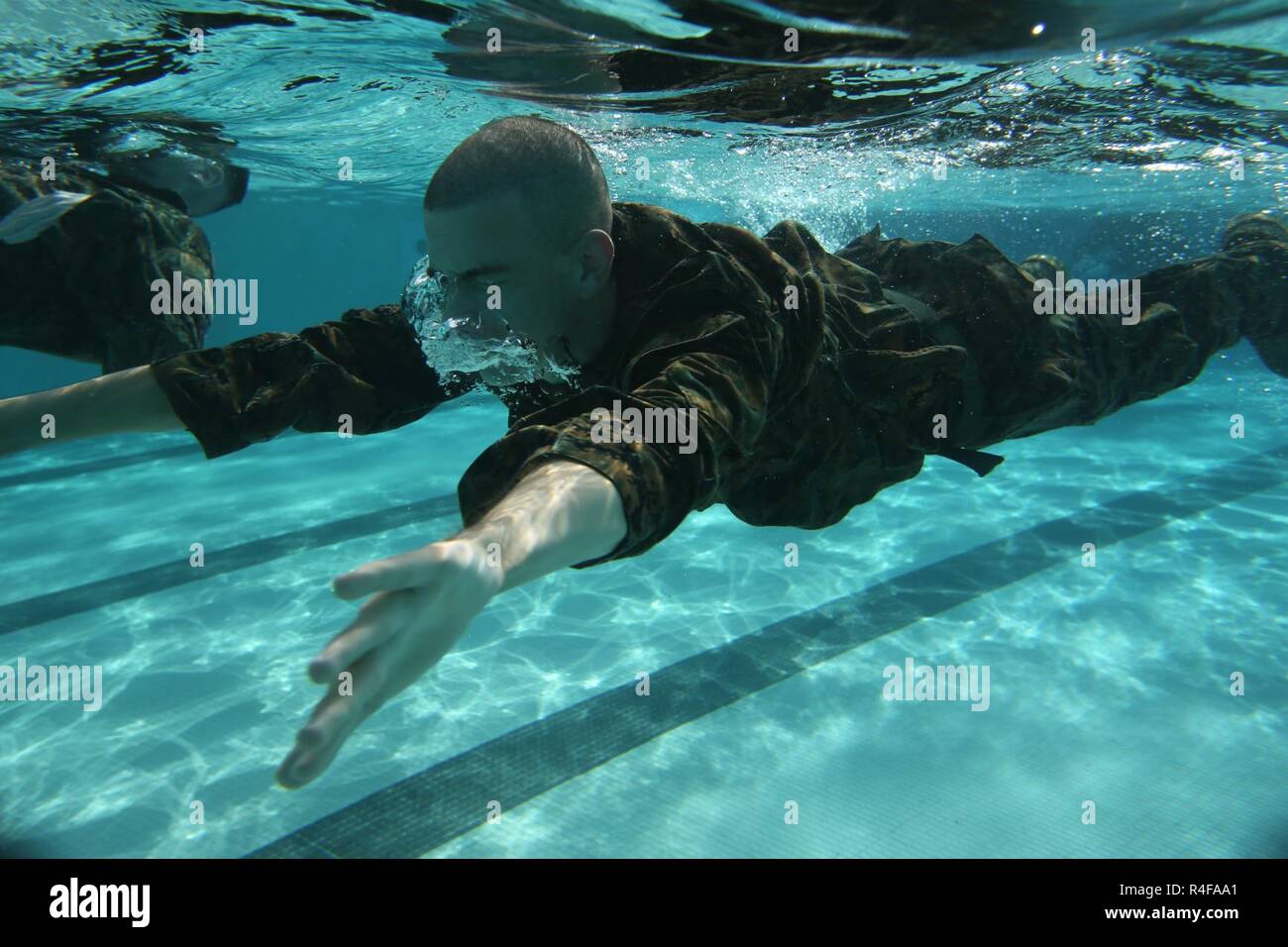 U.S. Marines with Headquarters and Support Battalion, Marine Corps Base Smedley D. Butler, conduct 250 meter swim during an intermediate swim qualification course at Camp Foster, Okinawa, Japan, Oct. 25, 2016. The purpose of the course is to maintain proficiency, and enhance the Marines skills in water survival techniques. Stock Photo