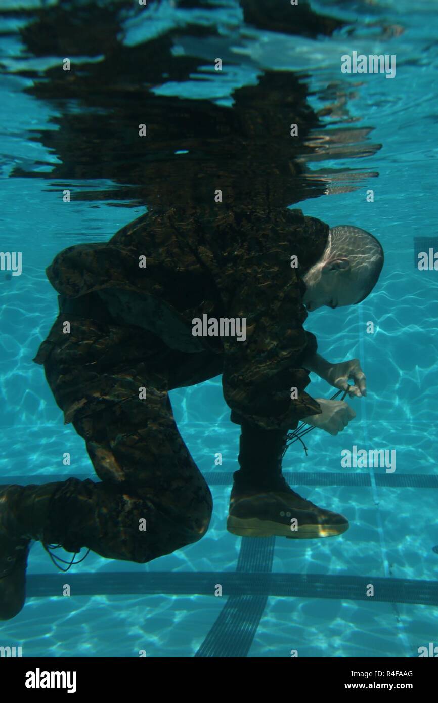 U.S. Marines with Headquarters and Support Battalion, Marine Corps Base Smedley D. Butler, prepare to demonstrate the trouser inflation technique during an intermediate swim qualification course at Camp Foster, Okinawa, Japan, Oct. 25, 2016. The purpose of the course is to maintain proficiency, and enhance the Marines skills in water survival techniques. Stock Photo