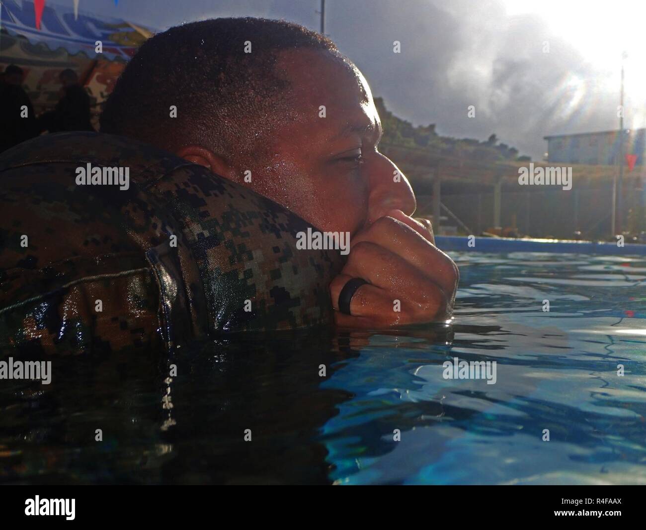 U.S. Marines with Headquarters and Support Battalion, Marine Corps Base Smedley D. Butler, demonstrate the blouse inflation technique during an intermediate swim qualification course at Camp Foster, Okinawa, Japan, Oct. 25, 2016. The purpose of the course is to maintain proficiency, and enhance the Marines skills in water survival techniques. Stock Photo