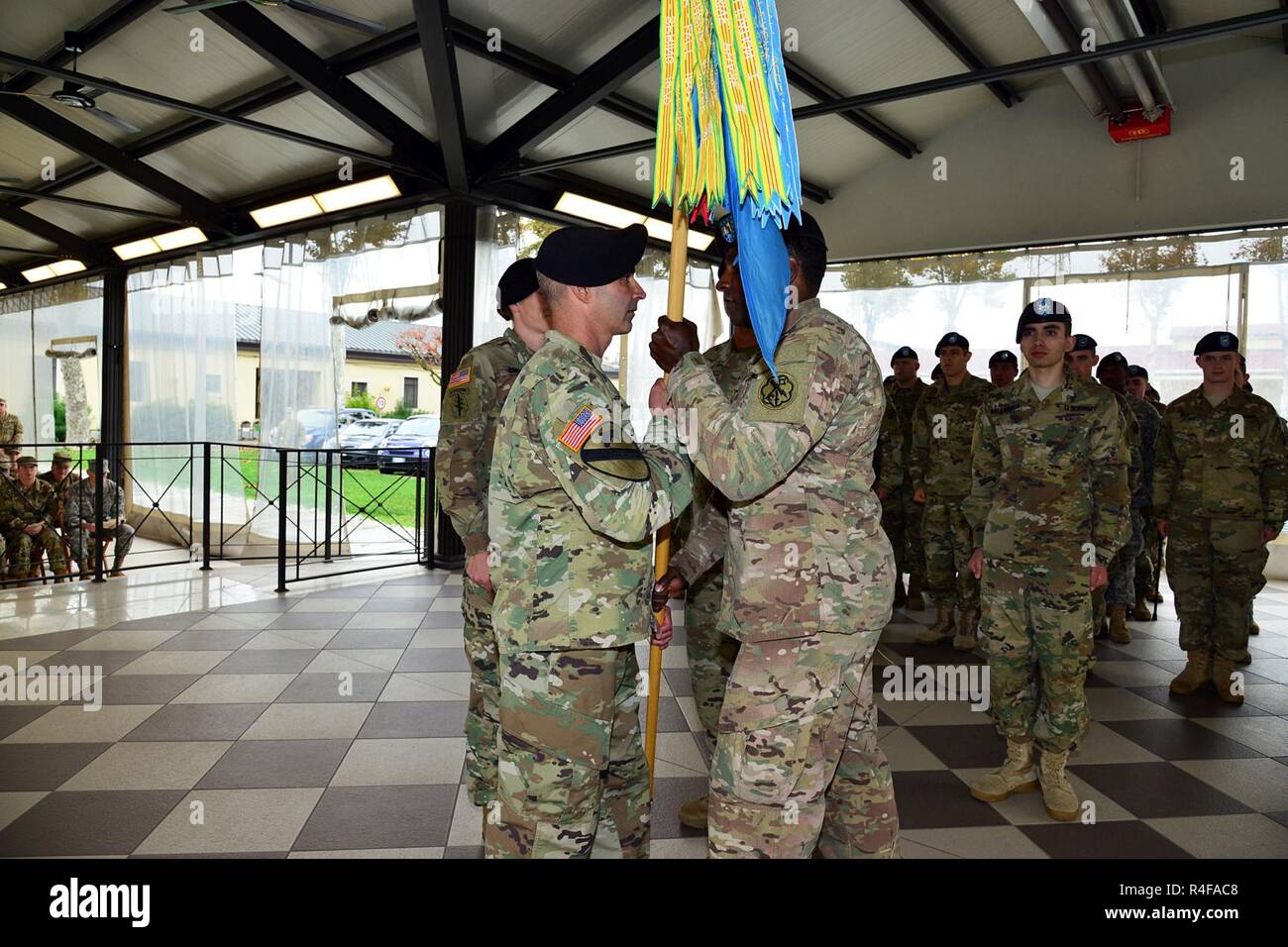 (From left) Lt. Col. Dylan Randazzo, commander of 307th Military Intelligence Battalion, receives the company guidon from Capt. Lawrence P. Lyons, former Bravo Company commander, Oct 24, 2016, during the change of command ceremony at Caserma Ederle in Vicenza, Italy. Stock Photo