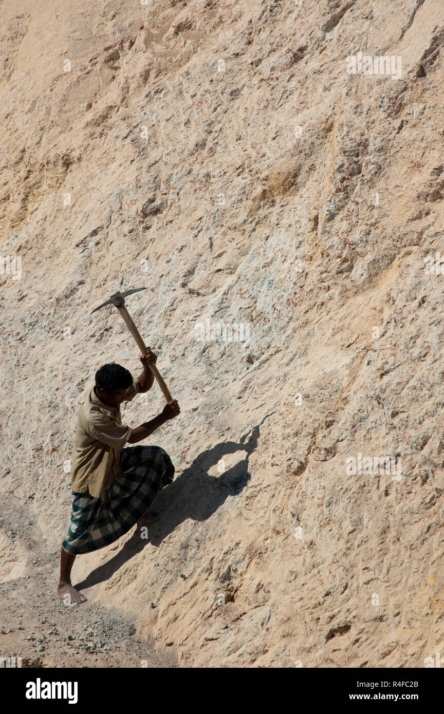 A worker cutting ceramic hill or white hill at Durgapur. Netrokona, Bangladesh. Stock Photo