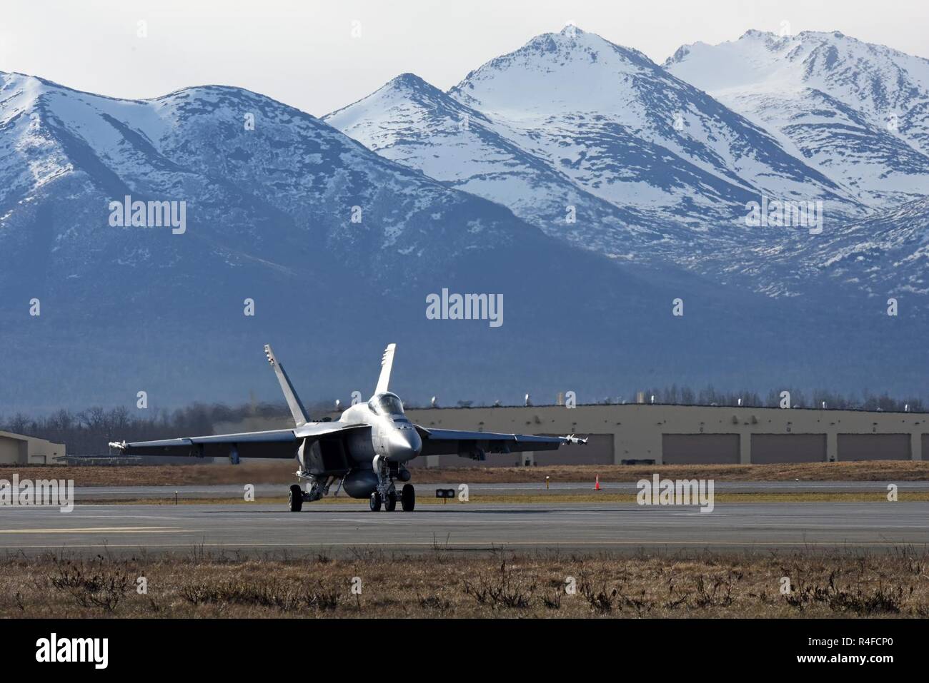 An F/A-18E Super Hornet attached to Strike Fighter Squadron 14 from Naval Air Station Lemoore, Calif., taxis down the ramp at Joint Base Elmendorf-Richardson, Alaska, prior to take-off May 3, 2017, in support of Exercise Northern Edge 2017. Northern Edge is Alaska’s largest and premier joint training exercise designed to practice operations, techniques and procedures, as well as enhance interoperability among the services. Thousands of participants from all the services—Airmen, Soldiers, Sailors, Marines and Coast Guard personnel from active duty, Reserve and National Guard units—are involved. Stock Photo