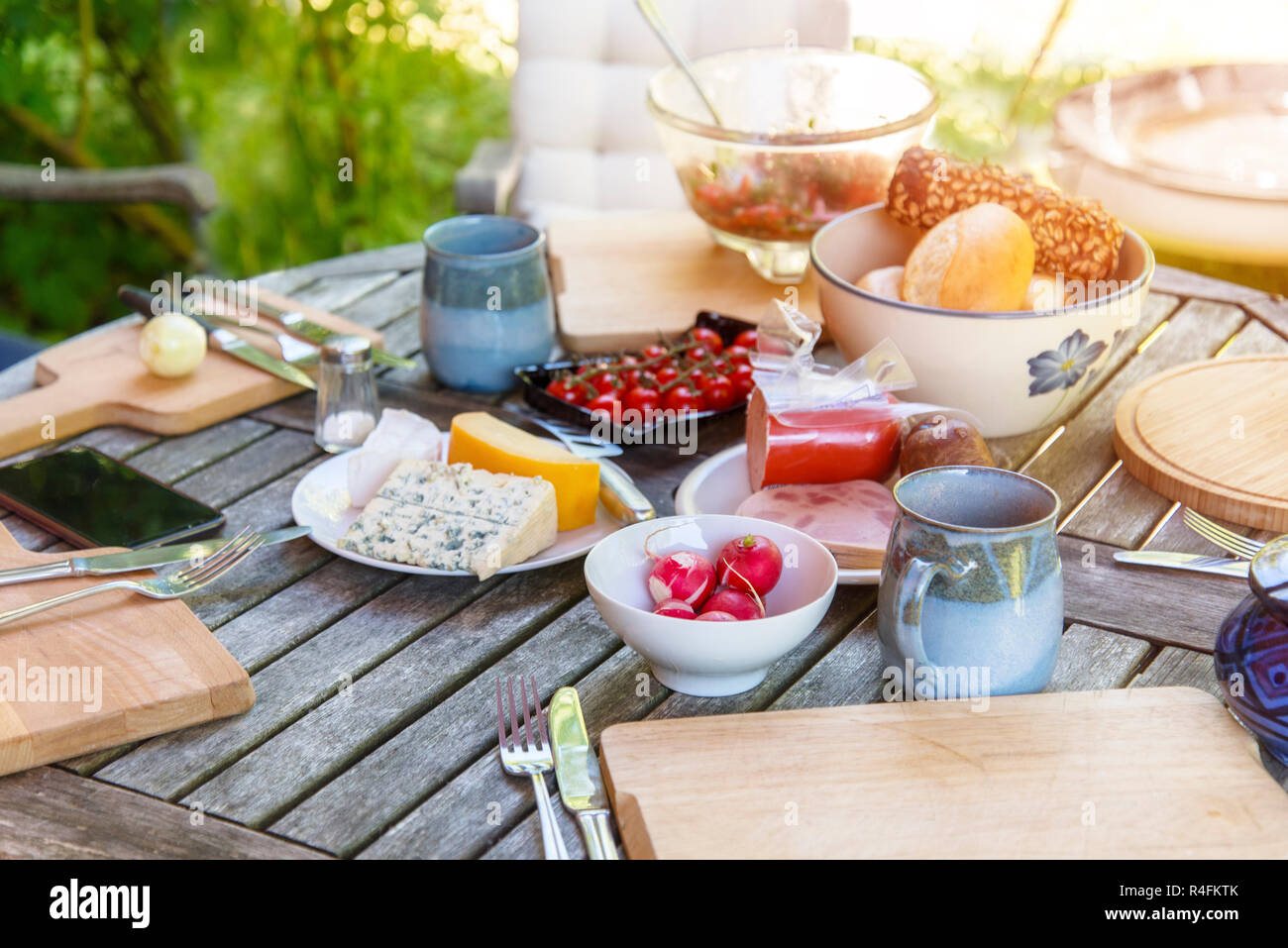 rustic garden table prepared for an outside meal with the family on a sunny day, selected soft focus Stock Photo