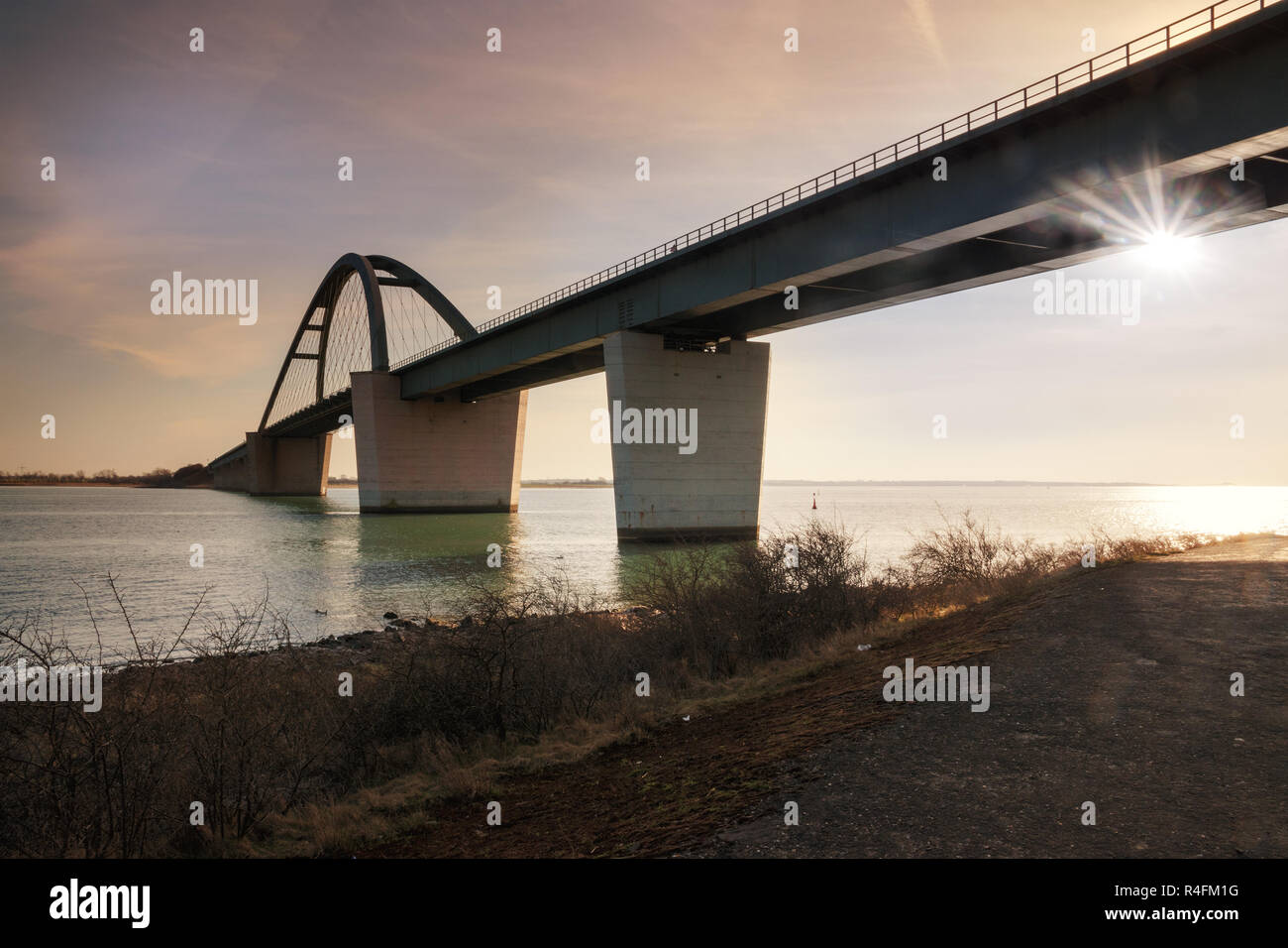 Fehmarn Sound Bridge in sunset (German: Fehmarnsundbrücke), suspension bridge with steel arches connecting the German mainland with the island in the Stock Photo