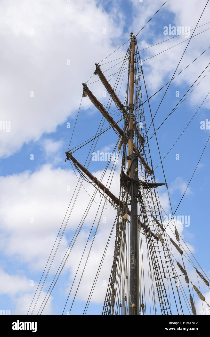 masts and rigging of a historic sailing ship against the cloudy sky ...