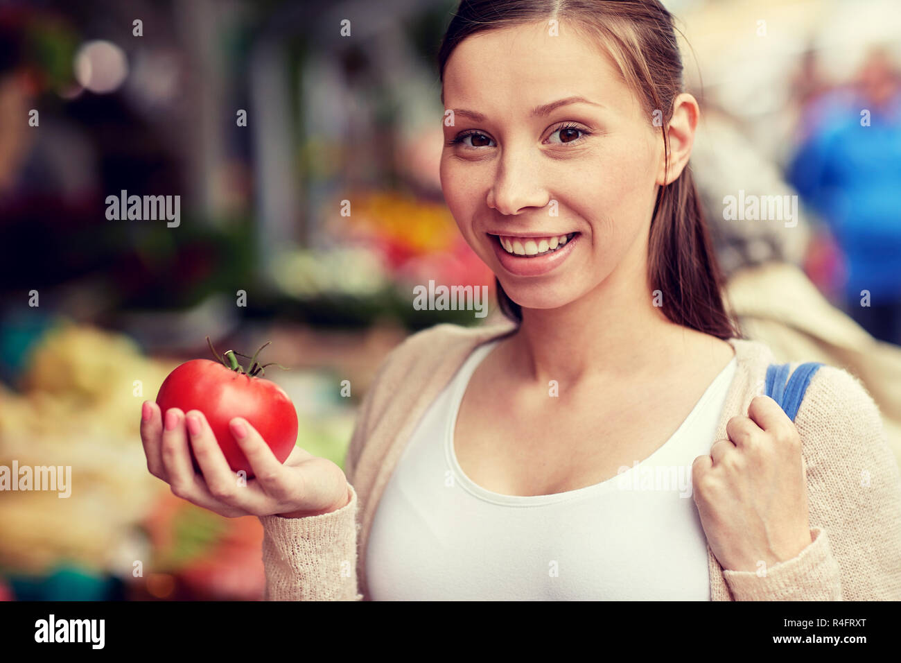happy woman holding tomato at street market Stock Photo - Alamy
