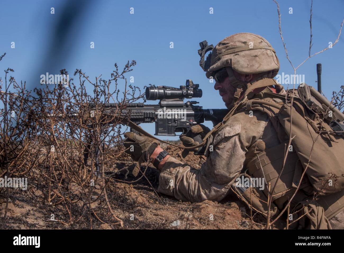 Lance Cpl. Seth Trunick, a scout rifleman with 1st Light Armored Reconnaissance Battalion, 1st Marine Division, takes up a firing position during a field exercise aboard Marine Corps Base Camp Pendleton, Calif., Oct. 25, 2016. The exercise was held as part of a week-long Marine Corps Combat Readiness Evaluation to ensure combat readiness before deployments.  This training allows Marines to become proficient and comfortable with their weapon systems in a realistic environment. Stock Photo