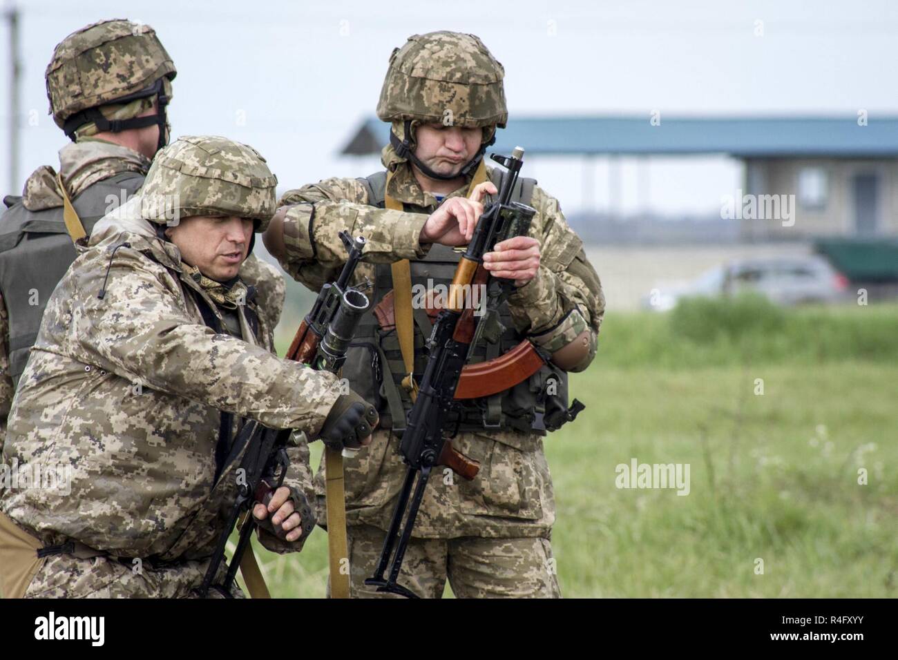 Ukrainian soldiers of the 1st Airmobile Battalion, 79th Air Assault Brigade inspect their GP-25 grenade launchers before using them during training at the Yavoriv Combat Training Center on the International Peacekeeping and Security Center, near Yavoriv, Ukraine, on May 3.    CTC trainers, partnered with Soldiers of the U.S. Army's 45th Infantry Brigade Combat Team, are teaching troops of the Ukrainian army's 1st Airmobile Battalion, 79th Air Assault Brigade how to employ the grenade launchers during defensive operations during the battalion's rotation at the CTC. The 45th IBCT is deployed as  Stock Photo