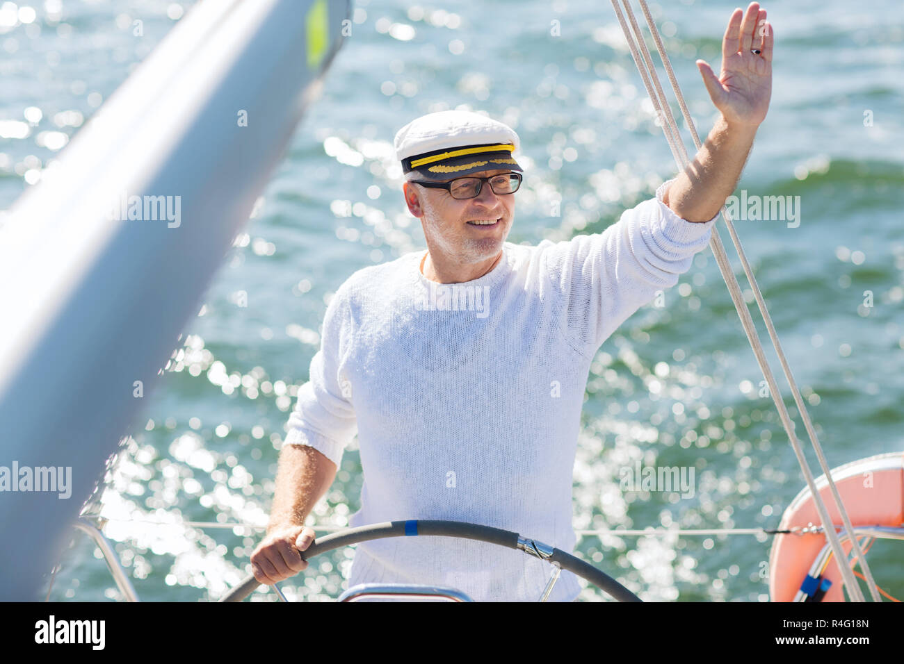senior man at helm on boat or yacht sailing in sea Stock Photo - Alamy