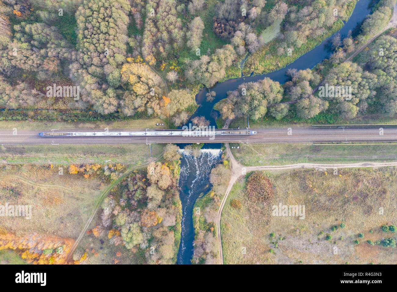 the train passes over the bridge over the river. view from above Stock Photo