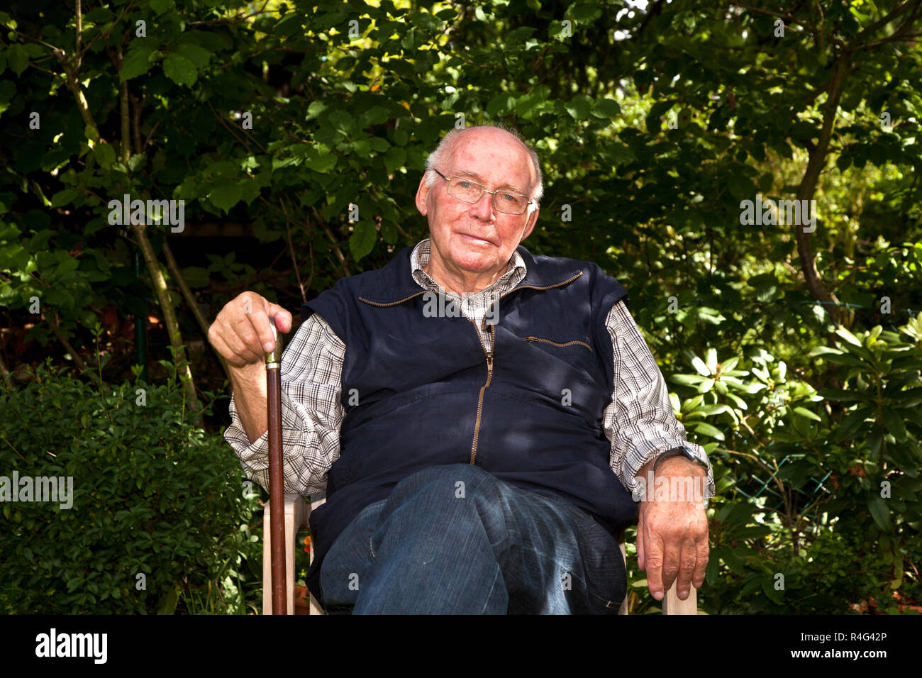 elderly man sitting in the garden Stock Photo