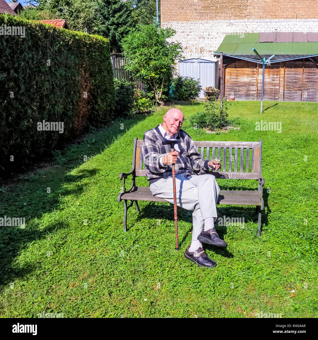 old man enjoys sitting on a bench in his garden Stock Photo - Alamy