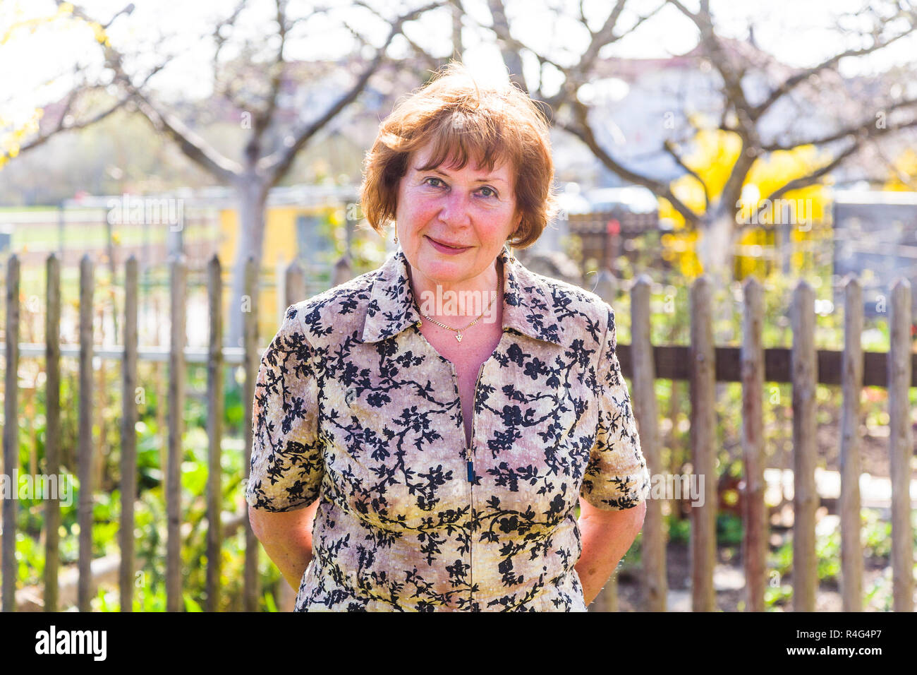 happy elderly woman is standing proud in her garden and smiles Stock ...