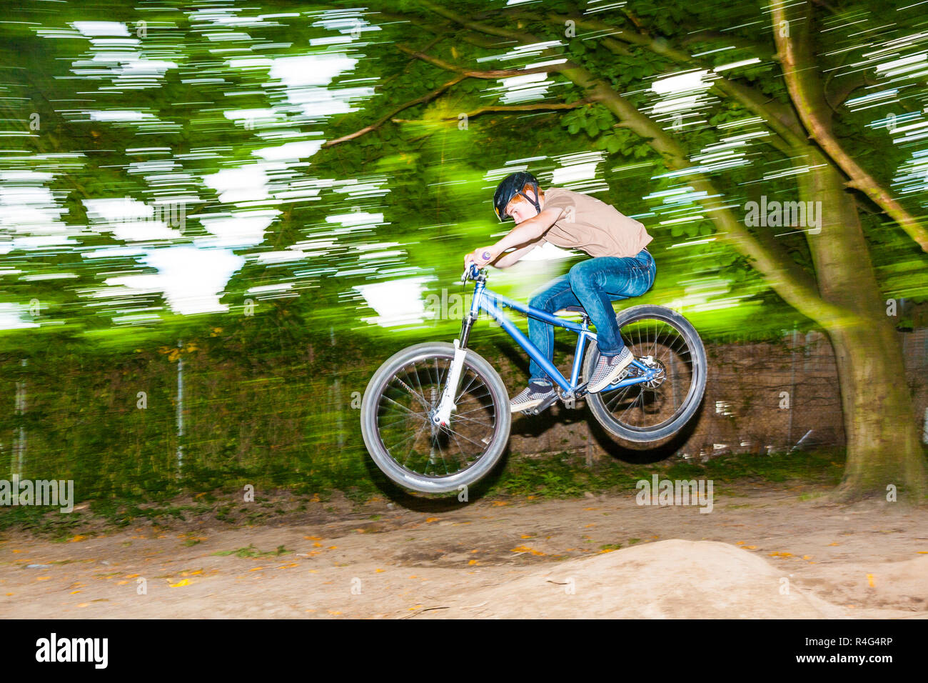 child has fun jumping with thΓΒ© bike over a ramp Stock Photo - Alamy