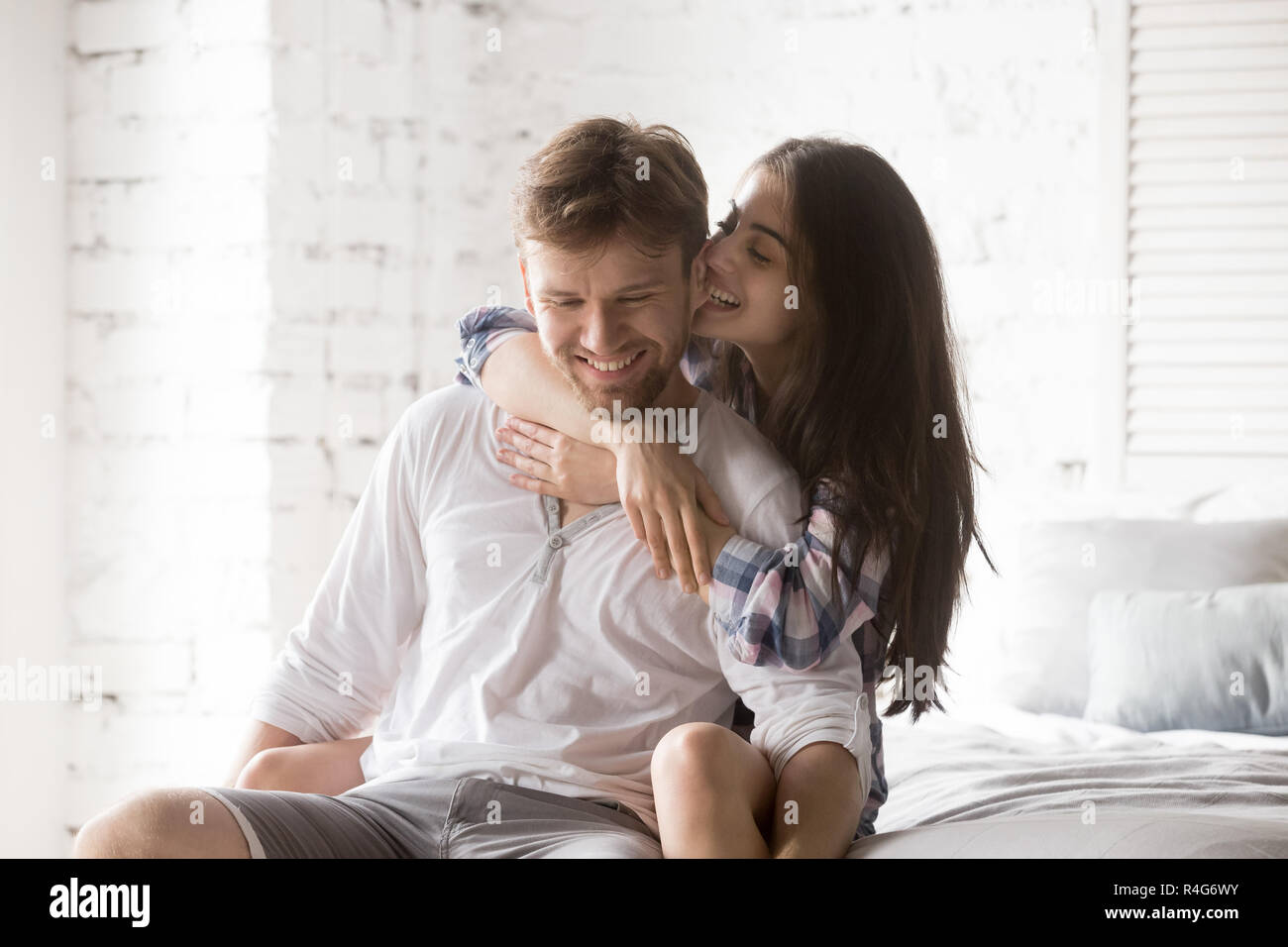 Young happy couple having fun together in bedroom at home Stock Photo