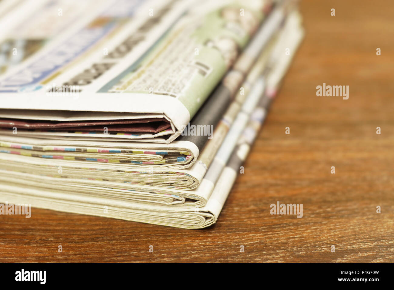 Pile of fresh morning newspapers on table at office. Latest financial and business news in daily paper. Pages with data. Folded and stacked journals Stock Photo