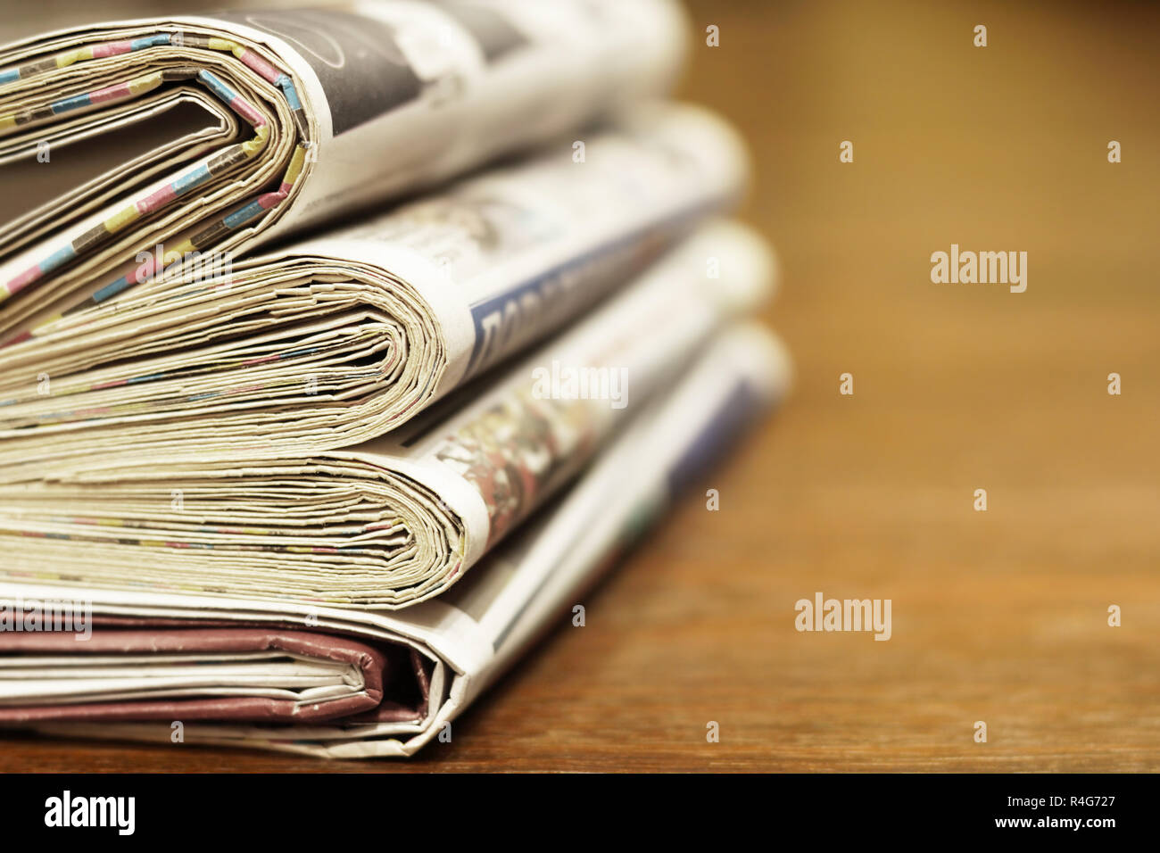 Pile of fresh morning newspapers on table at office. Latest financial and business news in daily paper. Pages with data. Folded and stacked journals Stock Photo
