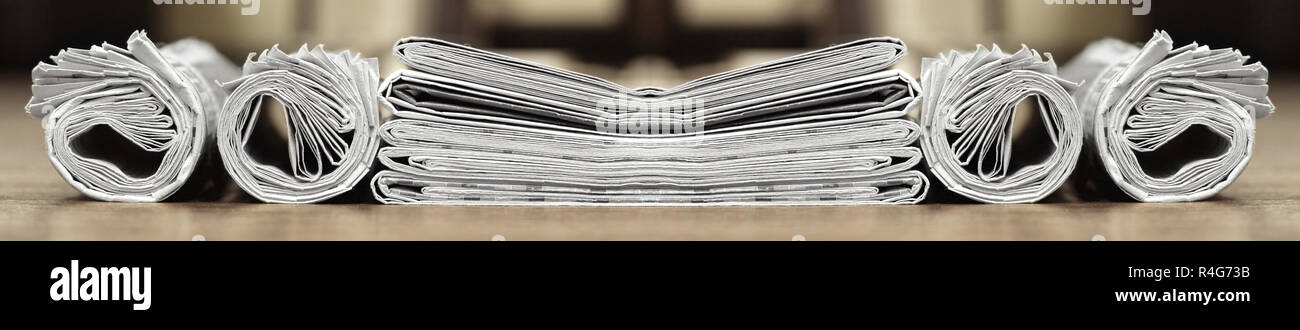 Long horizontal banner with rolled and folded newspapers and magazines in retro style. Concept for news and information - could be used for web design Stock Photo