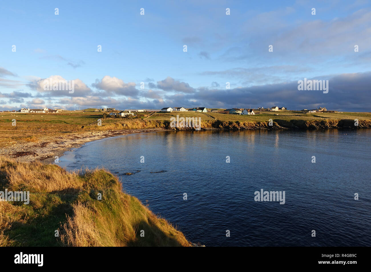 Low winter light in Hoswick Sandwick Shetland with homes around the