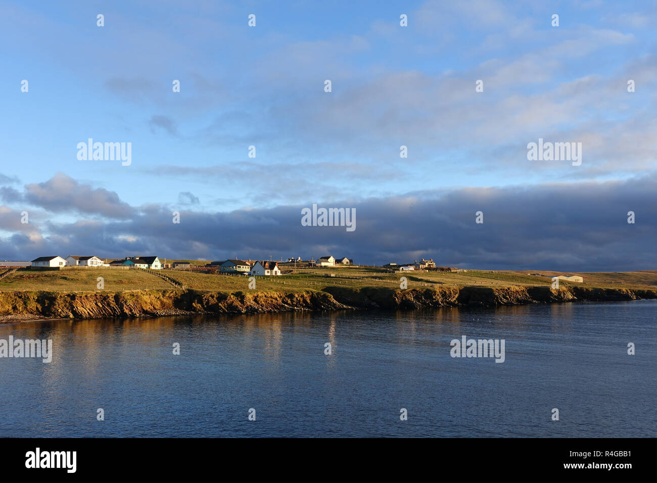 Low winter light in Hoswick Sandwick Shetland with homes around the