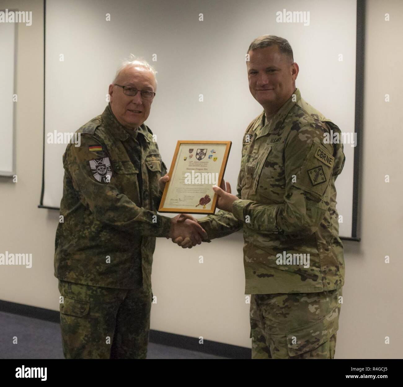 U.S. Army Brig. Gen. William E. King IV, Commander of the 20th CBRNE Command, receives an award from Col. Henry Neumann, Bundeswehr CBRN Commander, Satsop , Wash., May 2, 2017. Dragon fire is a bilateral exercise between the 48th Chemical, Biological, Radiological, and Nuclear (CBRN) Brigade and the German Bundswehr CBRN Defense command. It also serves as the culmination training event and validation exercise for the 22nd CBRN Battalion. Stock Photo