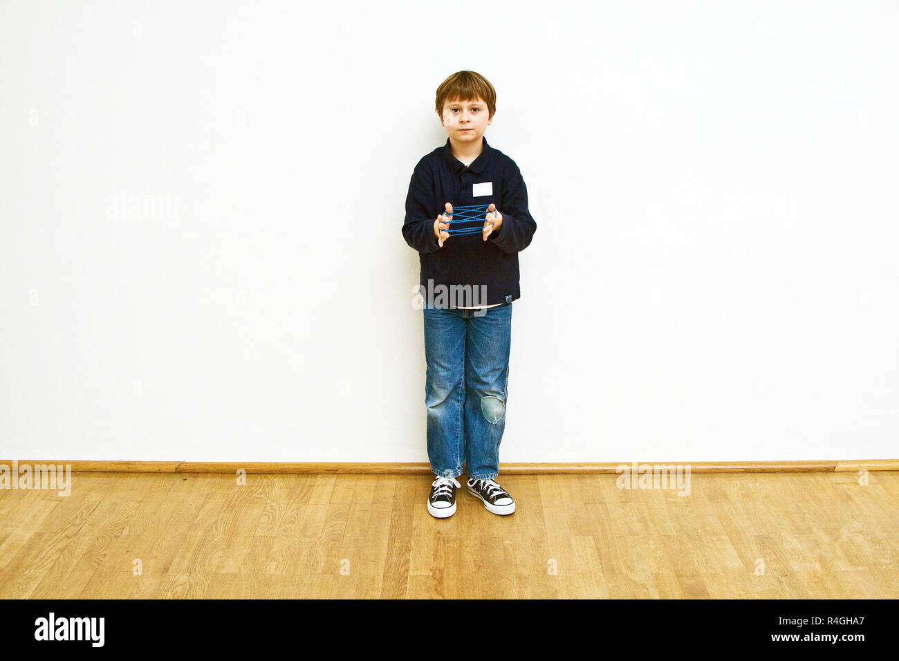 boy is playing a handgame with a band in a museum for modern Art, he enjoys it Stock Photo