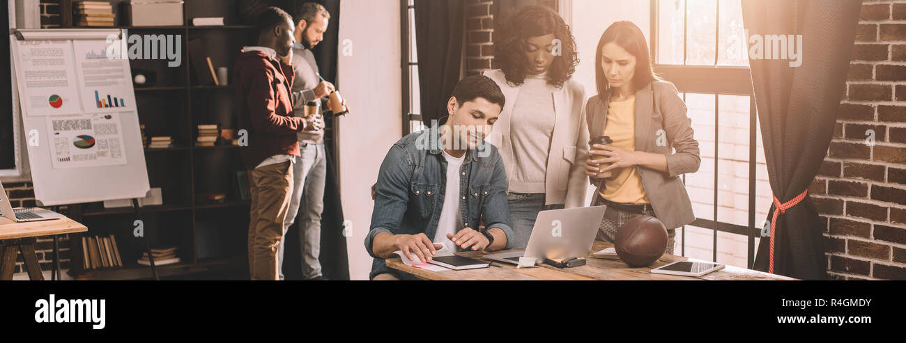 casual businesspeople working together using computer in loft office with backlit Stock Photo