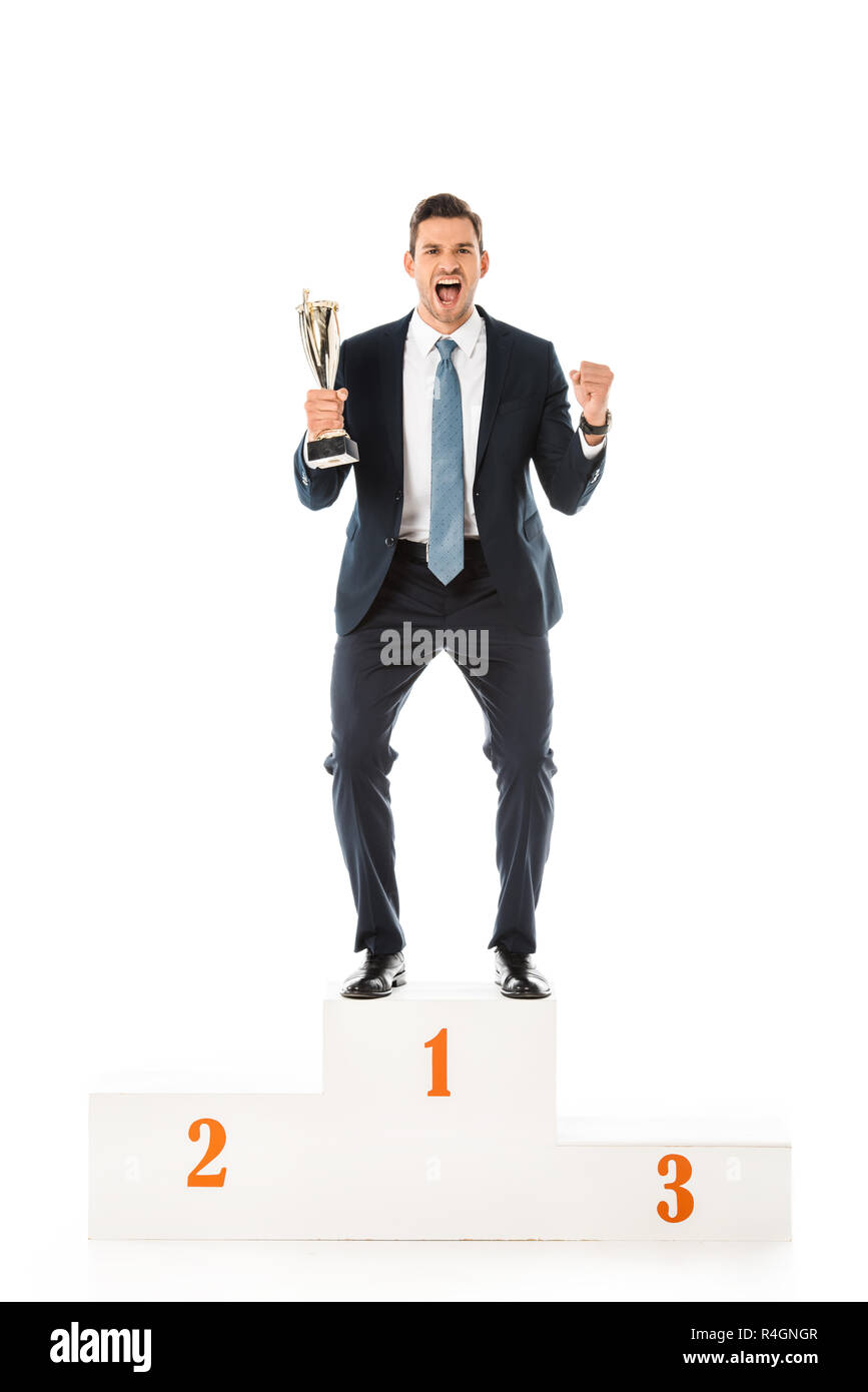 excited emotional businessman with trophy cup standing on winners podium isolated on white Stock Photo