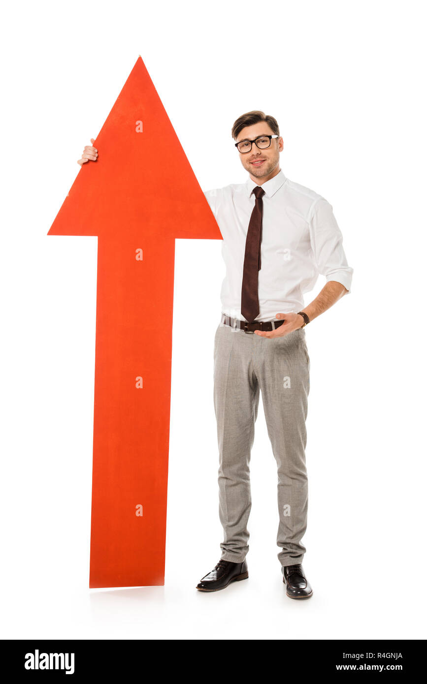 young handsome businessman standing with big red arrow isolated on ...