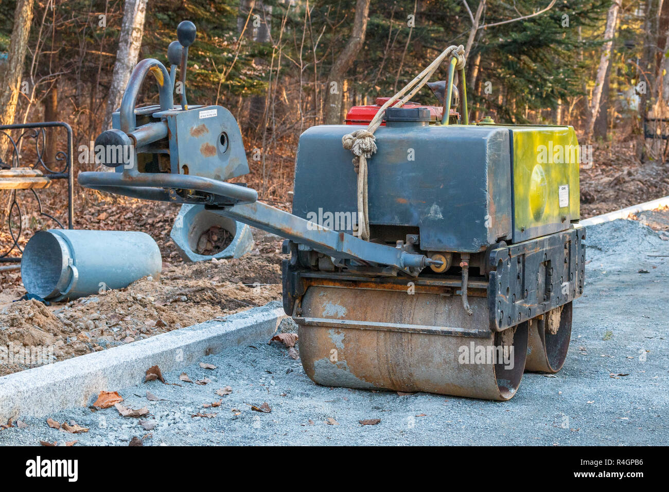Manual compact asphalt roller for tamping soil at a construction site