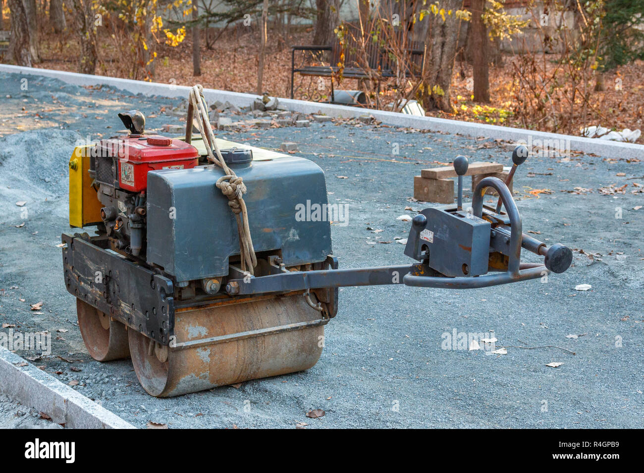 Manual compact asphalt roller for tamping soil at a construction site
