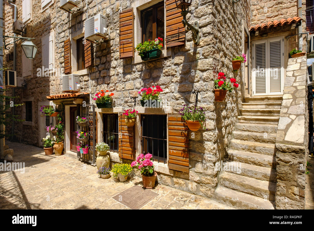 Alley with houses decorated with flowers, old town, Budva, Montenegro Stock Photo