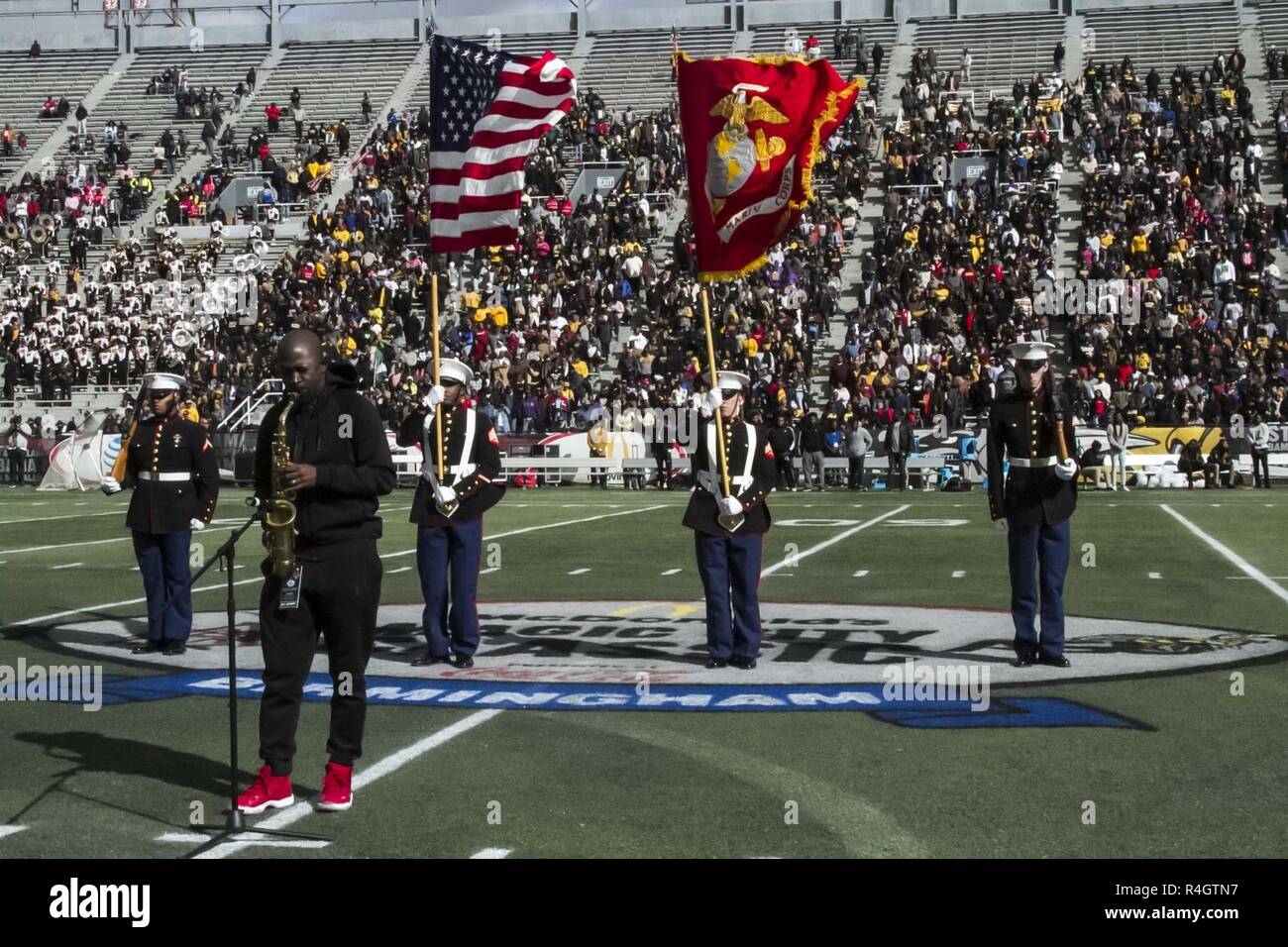Marines with 4th Combat Engineer Battalion, 4th Marine Division, based out of Bessemer, Alabama, present the colors while world-renowned saxophonist Mike Phillips performs the national anthem at the Magic City Classic, in Birmingham, Alabama, Oct. 27, 2018.  The Magic City Classic is a 77-year-old college football rivalry between Alabama A&M University and Alabama State University, the two largest historically black universities in the state. The Marine Corps participates in the rivalry to foster a positive relationship with the community and illustrate a parallel between the indelible fightin Stock Photo