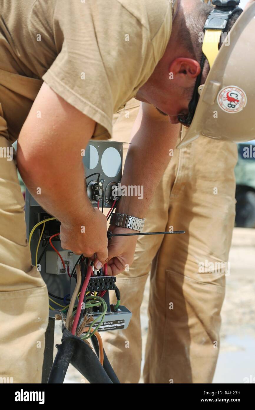 U.S. Navy Construction Electrician 2nd Class Ryan Thorne, assigned to Naval Mobile Construction Battalion (NMCB) 133, installs electrical cable in Riohacha, Colombia, Sept. 25, 2018, during water-well drilling exploration operations as part of Southern Partnership Station 2018. Southern Partnership Station is a U.S. Southern Command-sponsored and U.S. Naval Forces Southern Command/U.S. 4th Fleet-conducted annual deployment focused on subject matter expert exchanges and building partner capacity in a variety of disciplines including medicine, construction and dive operations in the Caribbean, C Stock Photo
