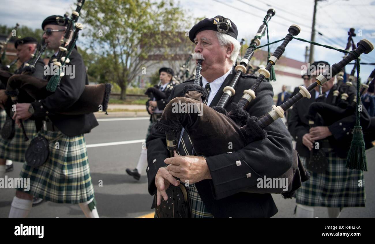 Procession participants play the bagpipes during a memorial dedication