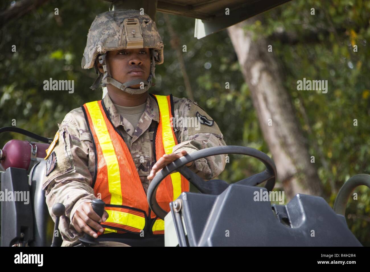 South Carolina National Guard Sgt. Shenna Taylor, a heavy equipment operator with the 1782nd Engineer Company, assists with local road repairs in Ruby, South Carolina after Hurricane Florence Sept. 30, 2018. More than 800 Guardsmen remain on duty as local counties take over recovery efforts. Stock Photo