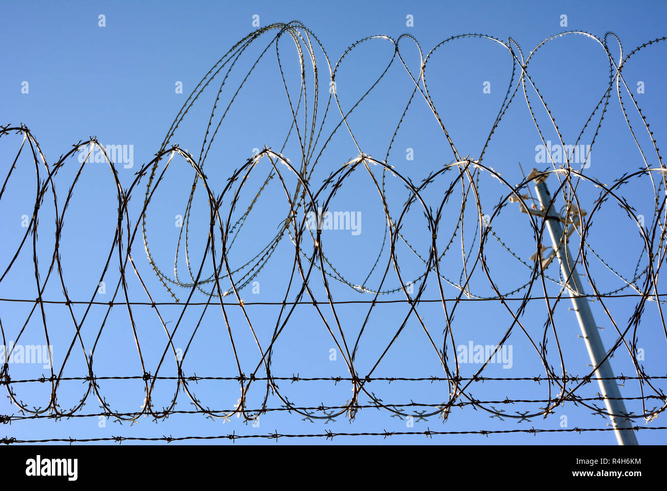 Barbed wire and Concertina wire atop the border wall separating the United States and Mexico. Stock Photo