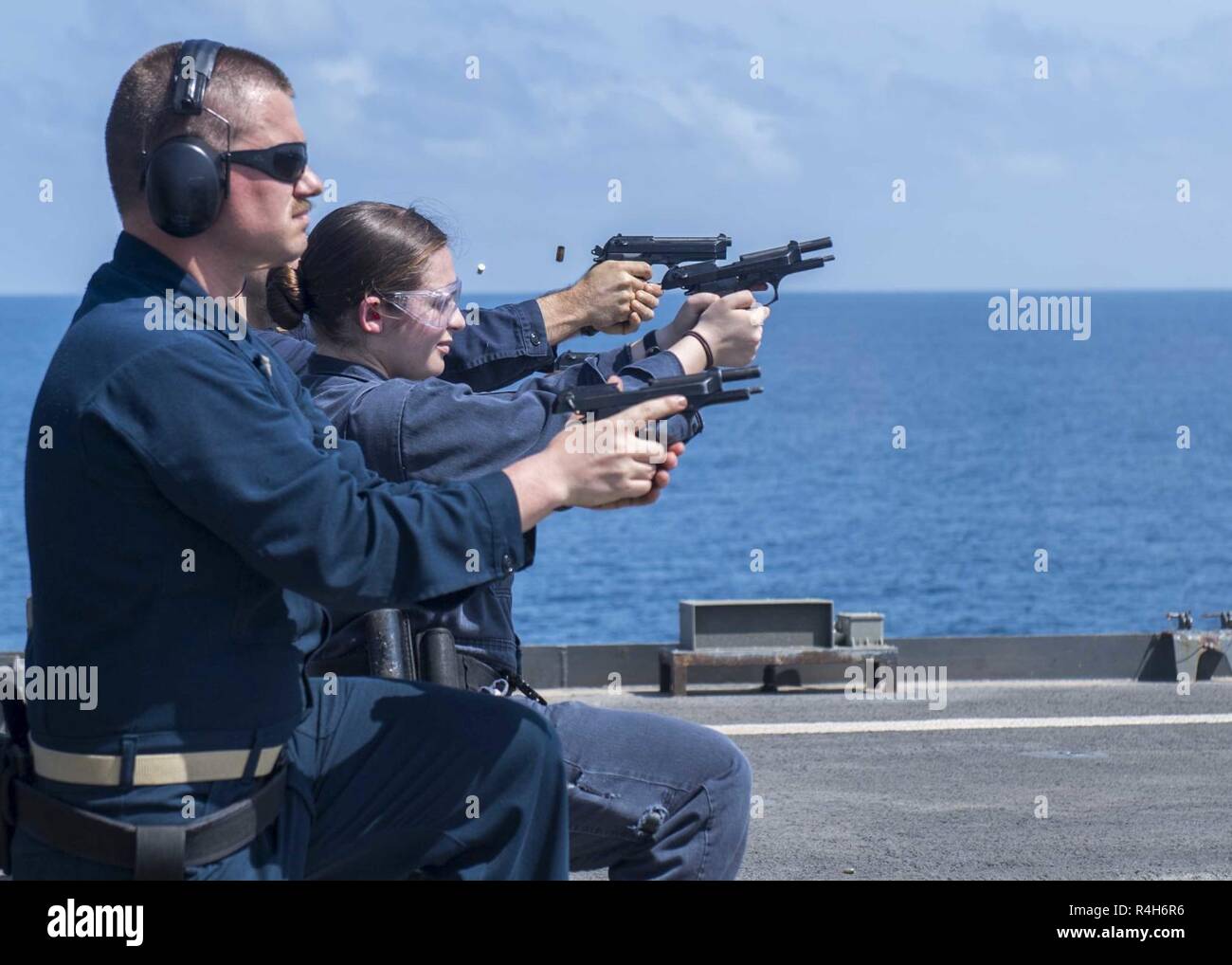 ARABIAN SEA (Sept. 24, 2018) Sailors assigned to Whidbey Island-class dock landing ship USS Rushmore (LSD 47) shoot M9 pistols while participating in a live-fire exercise during a regularly scheduled deployment of the Essex Amphibious Ready Group (ARG) and 13th Marine Expeditionary Unit (MEU). The Essex ARG/13th MEU is lethal, flexible, and persistent Navy-Marine Corps team deployed to the U.S. 5th Fleet area of operations in support of naval operations to ensure maritime stability and security in the Central Region, connecting to the Mediterranean and the Pacific through the western Indian Oc Stock Photo