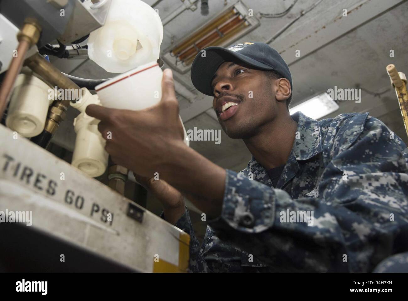 PORTSMOUTH, Va. (Oct. 3, 2018) Airman Christian Neal, from Washington, repairs a corrosion cart fuel filter in the hangar bay of the aircraft carrier USS Dwight D. Eisenhower (CVN 69). Ike is undergoing a Planned Incremental Availability (PIA) at Norfolk Naval Shipyard during the maintenance phase of the Optimized Fleet Response Plan (OFRP). Stock Photo