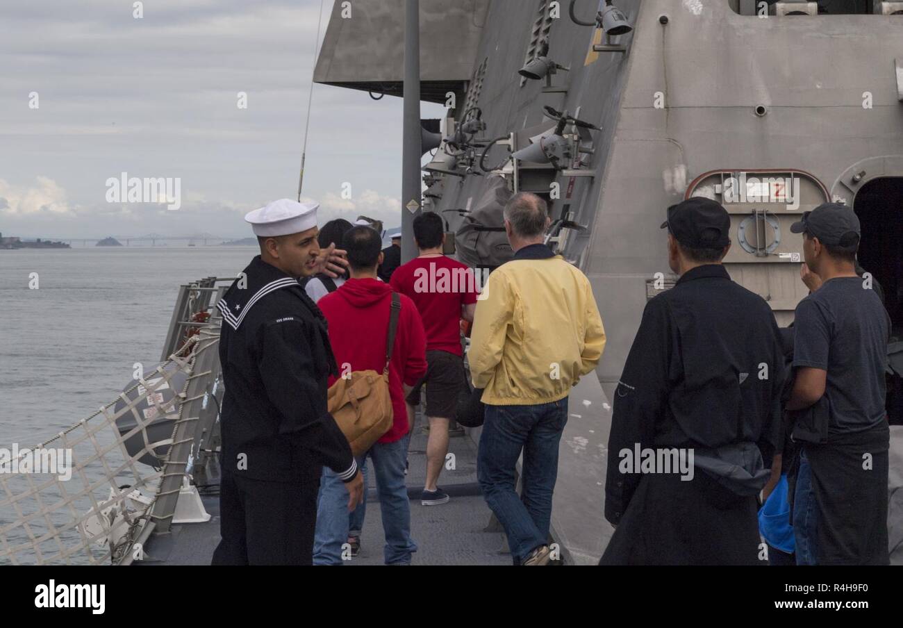 SAN FRANCISCO (Oct. 3, 2018) Boatswain’s Mate 1st Class Salvador Grajeda gives a guided public tour of the Independence-variant littoral combat ship USS Manchester (LCS 14) during San Francisco Fleet Week (SFFW) 2018. SFFW is an opportunity for the American public to meet their Navy, Marine Corps and Coast Guard teams and experience America's sea services. During fleet week, service members participate in various community service events, showcase capabilities and equipment to the community, and enjoy the hospitality of San Francisco and its surrounding areas. Stock Photo
