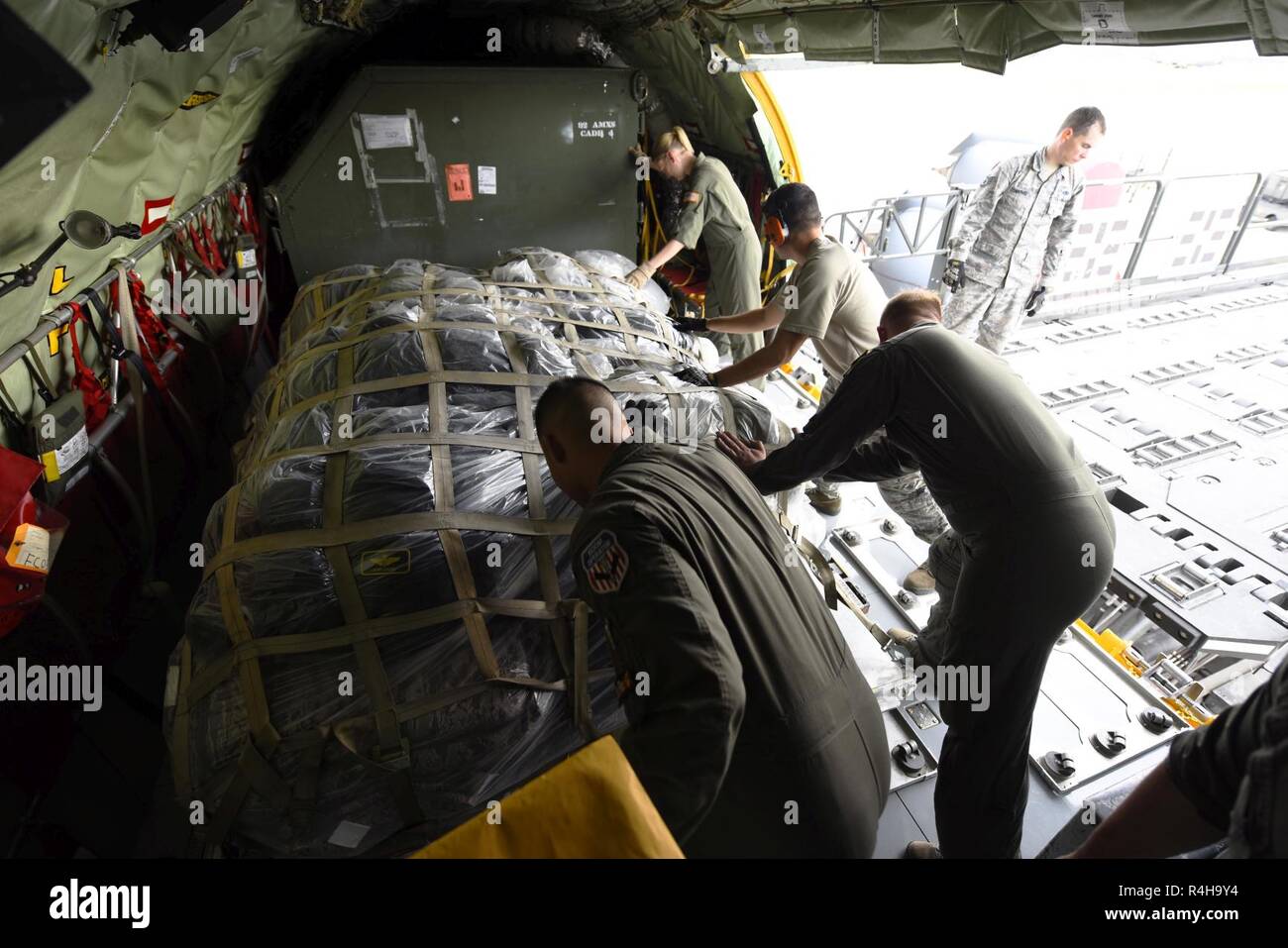 Airmen from the 92nd Air Refueling Squadron and Logistics Readiness Squadron push cargo into a KC-135 Stratotanker at Fairchild Air Force Base, Washington, September 2018. Mobility Airmen fuel the fight, provide airlift needed for supplies and personnel, and enable versatile and timely effects through contingency response ensuring mission success. Stock Photo
