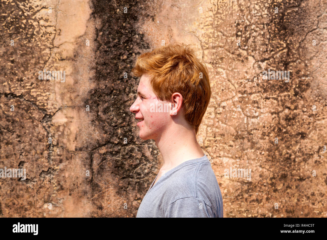 Portrait Of 16 Years Old Boy With Red Hair With Grunge Background