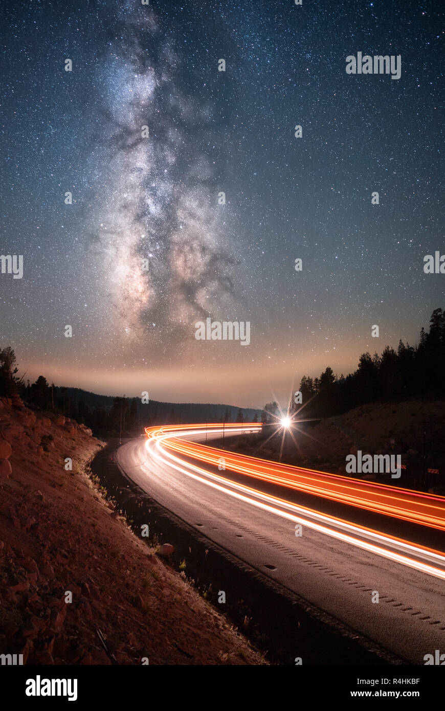 Milky Way above cars driving along a mountain road, Mt Rose, Nevada, United States Stock Photo