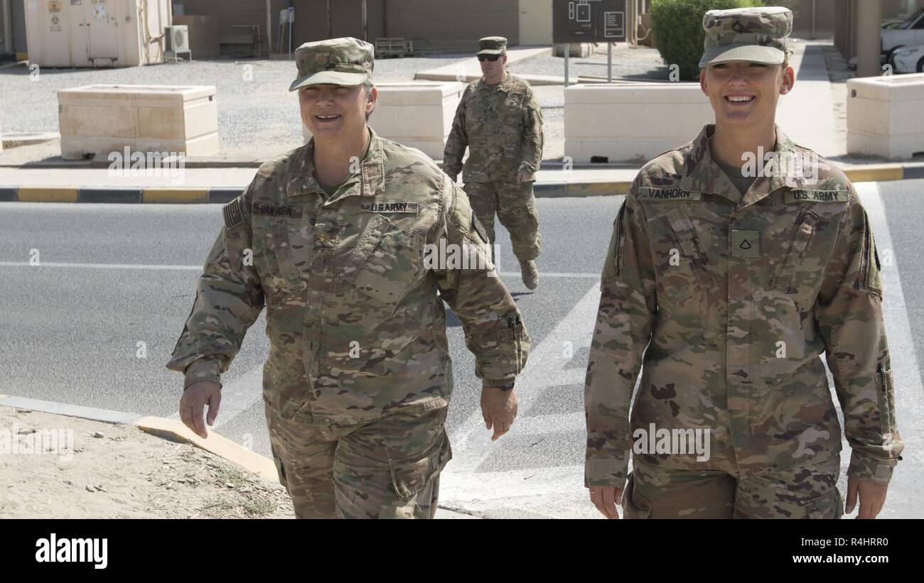 U.S. Army Maj. Lisa Van Horn, the chief of patient administration at the 452nd Combat Support Hospital, and her daughter Pvt. 1st Class Jenna Van Horn, a pharmacy specialist with the 452nd CSH, walk to lunch together, Camp Arifjan, Kuwait, Oct. 3, 2018. The work done by Soldiers in the  452nd CSH ensures that service members stationed in Central Command's area of responsibility remain healthy and capable of accomplishing their mission. Stock Photo