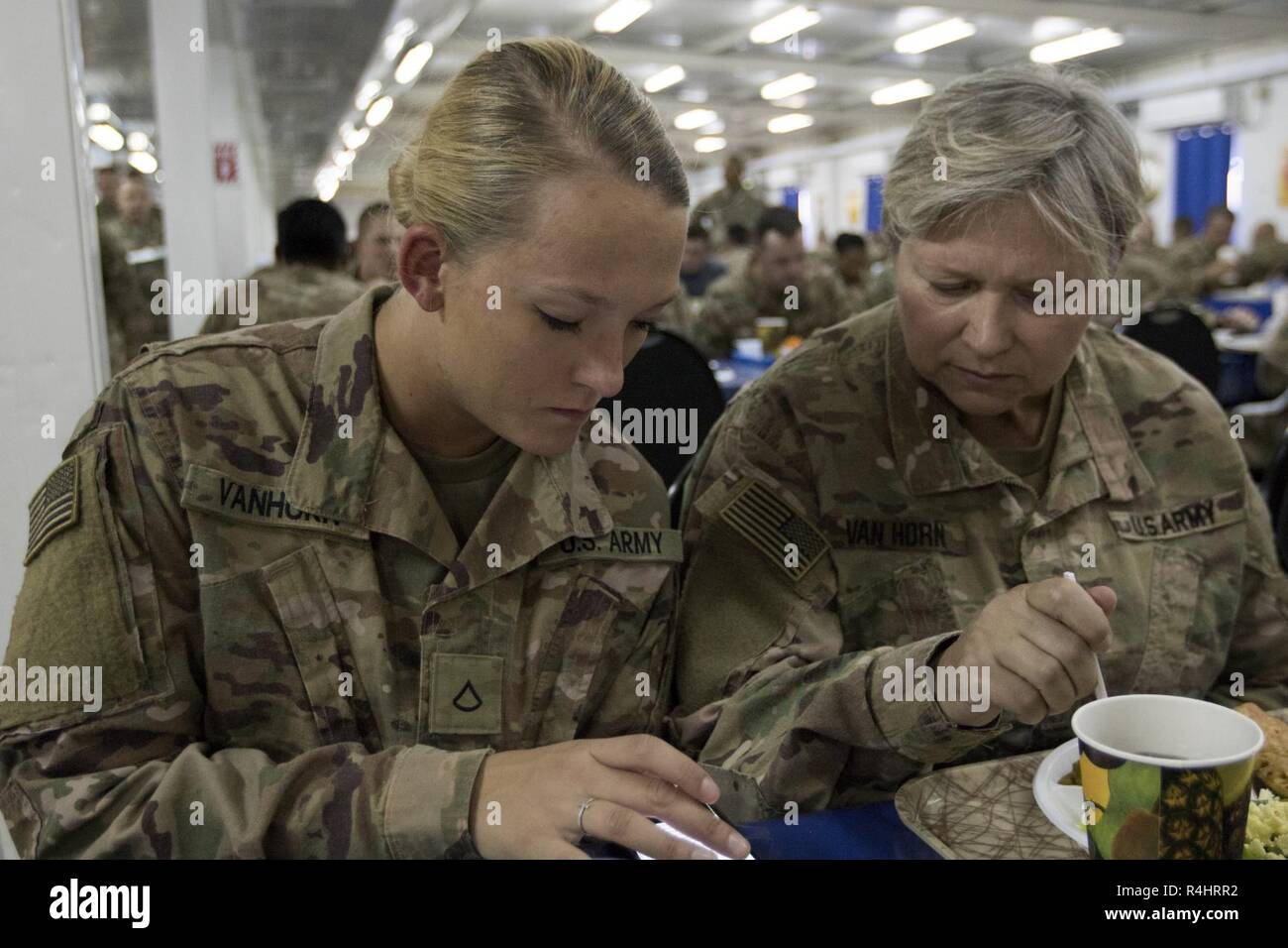 U.S. Army  Pvt. 1st Class Jenna Van Horn, a pharmacy specialist with the 452nd Combat Support Hospital, and her mother U.S. Army Maj. Lisa Van Horn, the chief of patient administration at the 452nd CSH, have lunch together, Camp Arifjan, Kuwait, Oct. 3, 2018. The work done by Soldiers in the  452nd CSH ensures that service members stationed in Central Command's area of responsibility remain healthy and capable of accomplishing their mission. Stock Photo