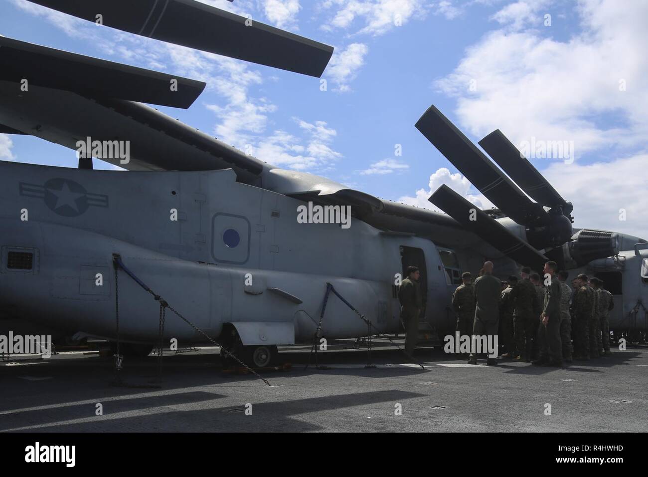 Marines with Company F, Battalion Landing Team, 2nd Battalion, 5th Marines, learn about an MV-22B Osprey tiltrotor aircraft during  a tour aboard  the amphibious assault ship USS Wasp (LHD 1), underway in the South China Sea, Sept. 26, 2018. BLT 2/5 is the Ground Combat Element for the 31st Marine Expeditionary Unit, currently underway aboard the Wasp as part of a regularly-scheduled patrol of the Indo-Pacific region. Company F, the helicopter-borne raid element with BLT 2/5, partner with the pilots and crew of Marine Medium Tiltrotor Squadron 262 (Reinforced) to conduct amphibious training an Stock Photo