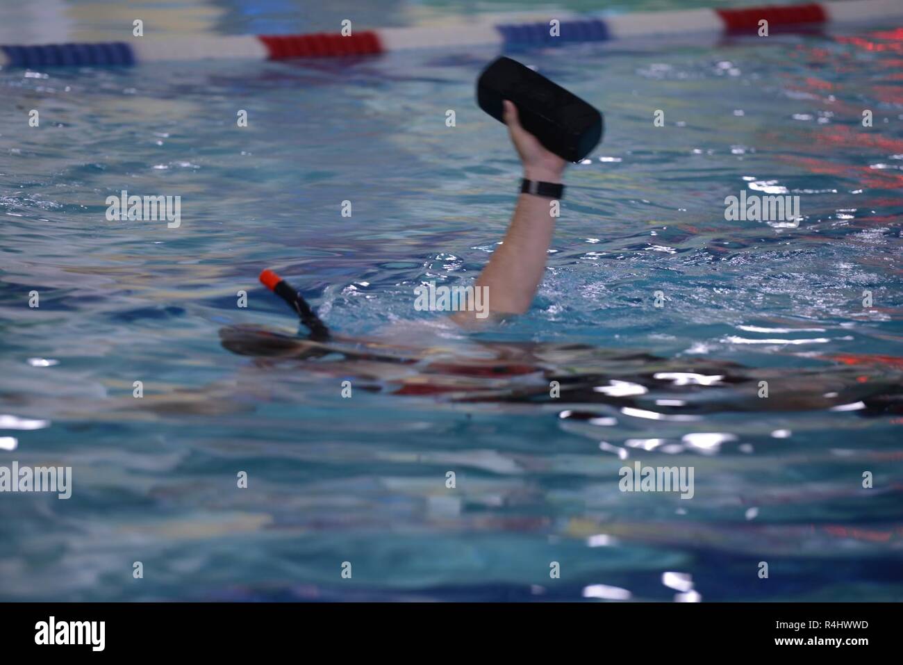 Seaman Ethan Bray, from Coast Guard Sector Columbia River, swims laps as he holds a 10-pound brick out of the water during training at the Astoria Aquatic Center in Astoria, Ore., Sept. 25, 2018.    This training is used to simulate immobilizing much of the upper body, so the swimmer has to use the legs to move through the water as they would need to do during a rescue of a person.    U.S. Coast Guard Stock Photo