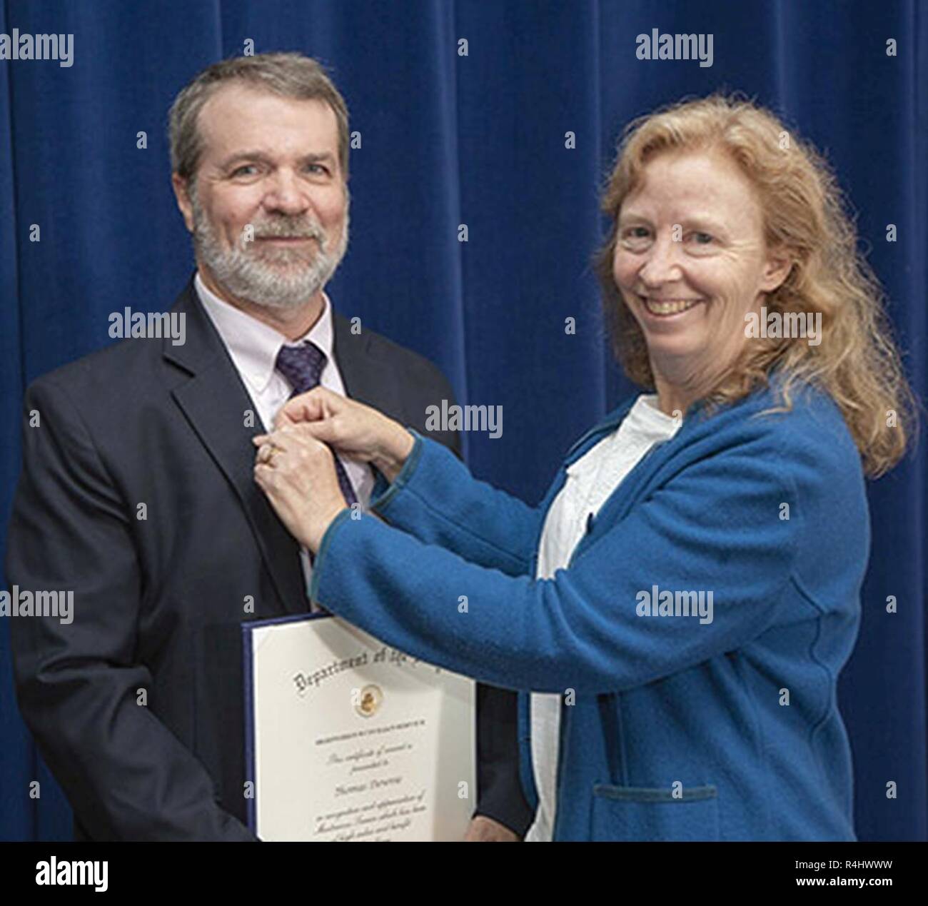 Thomas Downie (left photo) has his medal pinned by his wife, Deborah, after receiving his Department of the Navy Meritorious Civilian Service Award during an Oct. 1 awards ceremony. Stock Photo